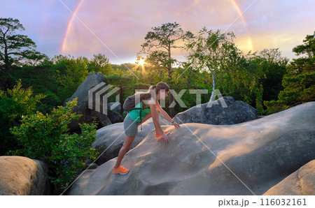 Young woman climbing alone on rocky mountain path. Female hiker enjoying difficult challenge on wilderness trail. Active way of life concept 116032161