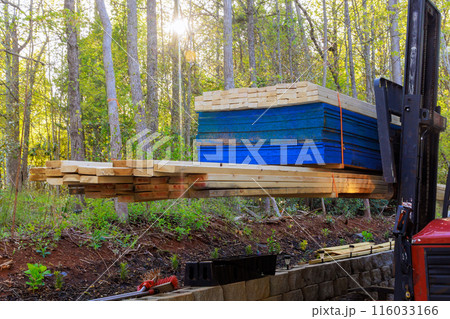 An employee of construction company using forklift to deliver building materials on construction site 116033166