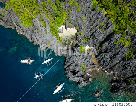 Top view of boats over blue water. Secret Beach in Matinloc, El Nido, Philippines. Top view of boats over blue water. Secret Beach in Matinloc, El Nido, Philippines. 116035506