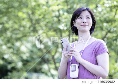 新緑の公園でスマホを使う女性 新緑の公園でスマホを使う女性 116035982