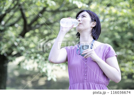 新緑の公園で水分補給する女性 116036674