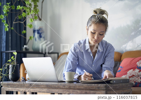 mature asian woman working from home using notebook computer 116037815