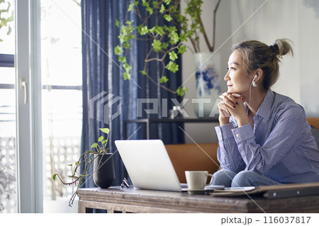 mature asian woman working from home using notebook computer 116037817