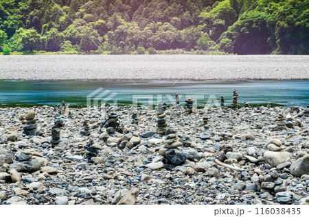 川辺に石が積み上げられ三途の川のような風景が広がる熊野川 116038435