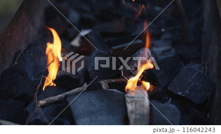Handheld shot of charcoal in brazier, preparation for bbq 116042243