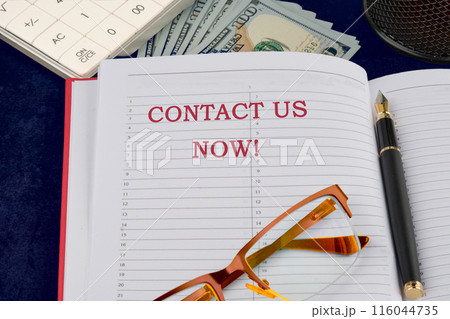 Conceptual contact us now symbol. Copy space. Contact us now words written in a business notebook in a composition with money, glasses, a fountain pen and parts of a calculator Conceptual contact us now symbol. Copy space. Contact us now words written in a business notebook in a composition with money, glasses, a fountain pen and parts of a calculator 116044735