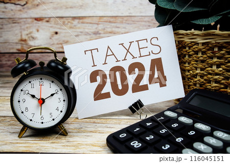 Taxes 2024 text with alarm clock and calculator on wooden background Taxes 2024 text with alarm clock and calculator on wooden background 116045151