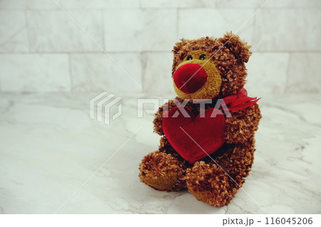 Teddy bear with red heart on marble background Teddy bear with red heart on marble background 116045206