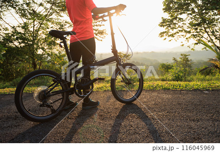 Riding folding bike on sunny mountain top road 116045969
