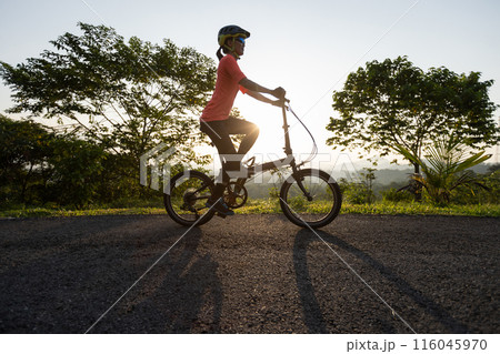 Riding folding bike on sunny mountain top road 116045970