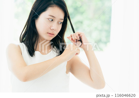 髪の傷みが気になる若い女性 116046620