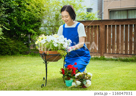 寄せ植えをする笑顔のミドル女性 116047031