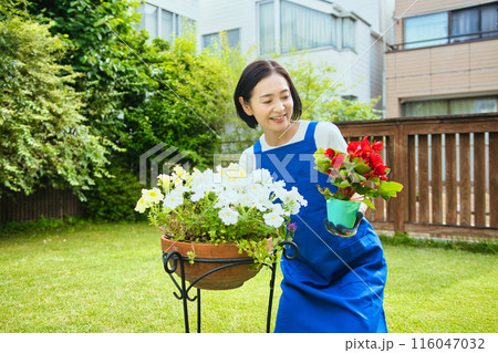 寄せ植えをする笑顔のミドル女性 116047032