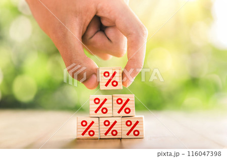 Interest rate financial and mortgage rates concept. Hand putting wood cube block increasing on top with icon percentage symbol upward direction. Interest rate financial and mortgage rates concept. Hand putting wood cube block increasing on top with icon percentage symbol upward direction. 116047398