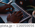 A person using a smartphone while working on a laptop at a cozy cafe. by Generative AI 116050056