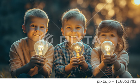 Children hold a glowing lightbulb with a curious expression. The concept of youthful curiosity, bight ideas, and the potential for innovation. 116052782