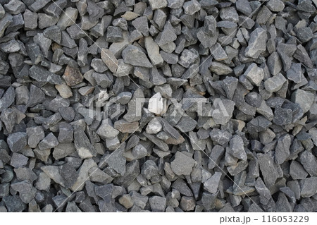 Grey rubble, crushed stone, background, hard texture backdrop. Copy space. Top view. Rocks with sharp edges, broken, close-up. Rough surface for design. 116053229