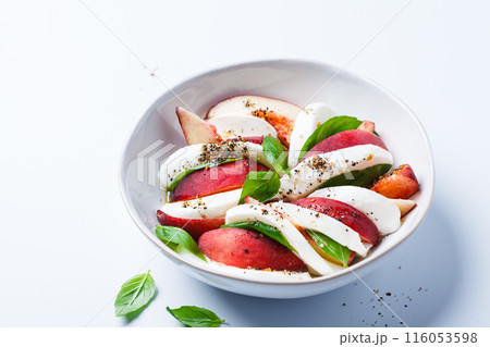 Caprese salad with peach, basil and mozzarella, white background. Caprese salad with peach, basil and mozzarella, white background. 116053598