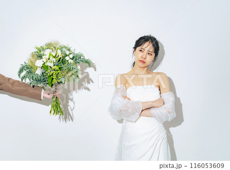 ブーケを渡されて悩むウェディングドレスを着た女性　ブライダルフォト　前撮り 116053609
