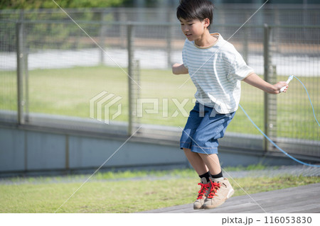 学校の校庭などで縄跳びを飛ぶ男子の小学生 116053830