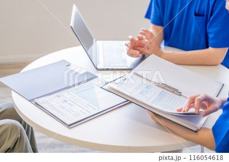 打合せをする男女の介護士の手元 打合せをする男女の介護士の手元 116054618