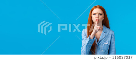 Quiet please Im trying sleep. Displeased and disturbed young redhead college girl living dormitory asking roommate be silent, shushing, say hush angry frowning, press index finger to lips 116057037