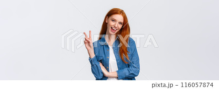 Business, university and people concept. Attractive cheerful redhead woman in denim shirt, send positivity and happiness, showing peace sign and smiling carefree, standing white background Business, university and people concept. Attractive cheerful redhead woman in denim shirt, send positivity and happiness, showing peace sign and smiling carefree, standing white background 116057874
