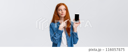 Tempting and curious attractive redhead woman found delicious meal on food delivery application, adding it to shopping card, want buy take-away, pointing smartphone screen, white background Tempting and curious attractive redhead woman found delicious meal on food delivery application, adding it to shopping card, want buy take-away, pointing smartphone screen, white background 116057875