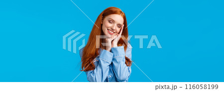 Waist-up shot tender and sensual redhead female in cute soft pyjama, applied nightcream, take-off cosmetics, getting ready sleep, wearing nightwear, close eyes and smiling delighted, blue background 116058199