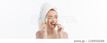 Attractive Young Woman with beautiful clean skin. White mask and cucumbers. Beauty treatments and cosmetology spa therapy. White background 116058200