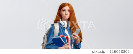 Indecisive, nervous cute redhead freshman girl, start new year college, looking worried camera, biting lip nervously, holding backpack, notebooks and smartphone, reading message 116058803