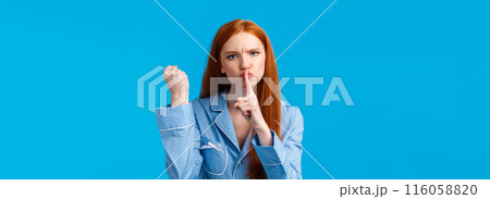 Shut up or else. Angry and displeased redhead girl threaten roommate be quiet and shaking fist, warning behave well, not tell anyone secret, make shush gesture mad, hushing over blue background Shut up or else. Angry and displeased redhead girl threaten roommate be quiet and shaking fist, warning behave well, not tell anyone secret, make shush gesture mad, hushing over blue background 116058820