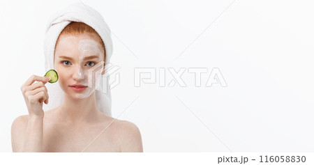 Attractive Young Woman with beautiful clean skin. White mask and cucumbers. Beauty treatments and cosmetology spa therapy. White background Attractive Young Woman with beautiful clean skin. White mask and cucumbers. Beauty treatments and cosmetology spa therapy. White background 116058830