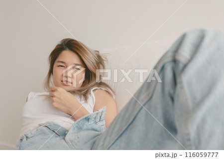 Woman lies and resting on the sofa, playing with her hair and relax. 116059777