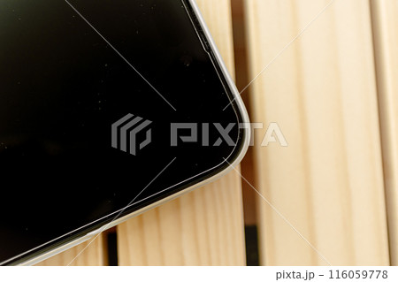 Close up of mobile phone wears white matte case left on wooden table. 116059778