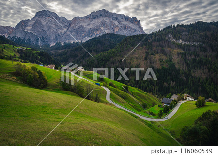 Winding mountain road on the green slope in Dolomites, Italy Winding mountain road on the green slope in Dolomites, Italy 116060539