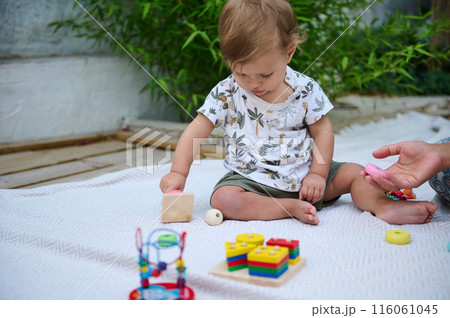 Little toddler playing with educational toys outdoors 116061045