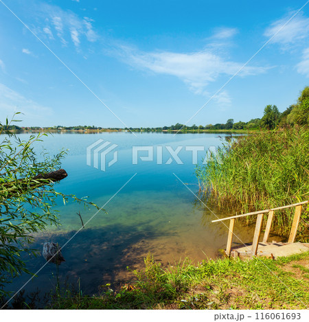Summer lake calm beach with wood steeps to the water Summer lake calm beach with wood steeps to the water 116061693