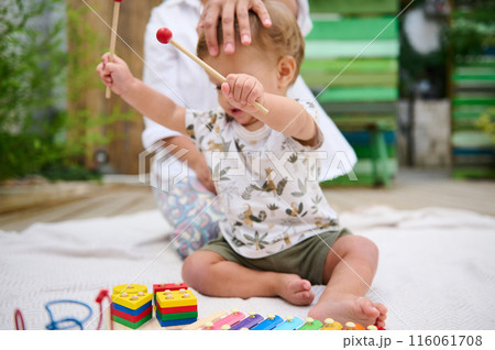 Toddler playing with toys at home with parental supervision 116061708