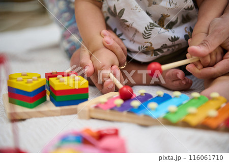 Parent and child playing with colorful educational toys 116061710
