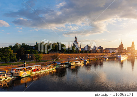 Scenic warm sunset beautiful Dresden city skyline at Elbe River with many steam tourist ship vessel moored at bank. Saxony Germany capital cityscape dusk panorama view with old Europe architecture Scenic warm sunset beautiful Dresden city skyline at Elbe River with many steam tourist ship vessel moored at bank. Saxony Germany capital cityscape dusk panorama view with old Europe architecture 116062171