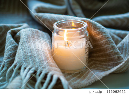 Create a cozy atmosphere with candlelight and a comfortable blanket for a relaxing ambiance Create a cozy atmosphere with candlelight and a comfortable blanket for a relaxing ambiance 116062621