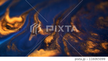Ink spill. Glitter fluid mix. Defocused blue gold color glowing sparkling marble texture acrylic wave dark abstract art background. 116065099