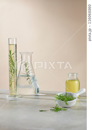Minimalist style photo on yellow background, vacant space on the lab table for product displaying, which has natural ingredient as tea tree, decorated with experiment instruments 116068860
