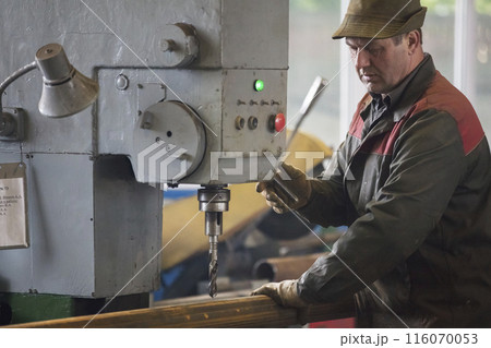 Worker at the current machine in the workshop. 116070053