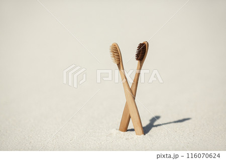Eco-Friendly Bamboo Toothbrushes Standing Upright on Sand Eco-Friendly Bamboo Toothbrushes Standing Upright on Sand 116070624