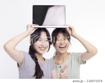 Two young beautiful smiling asian teenager female holding the laptop 116071074