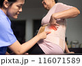 Physiotherapist checking senior women patient orthopedic corset at clinic 116071589