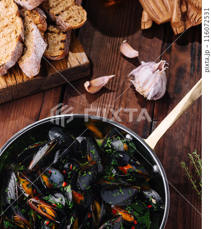 Appetizing mussels in herb broth with bread Appetizing mussels in herb broth with bread 116072531