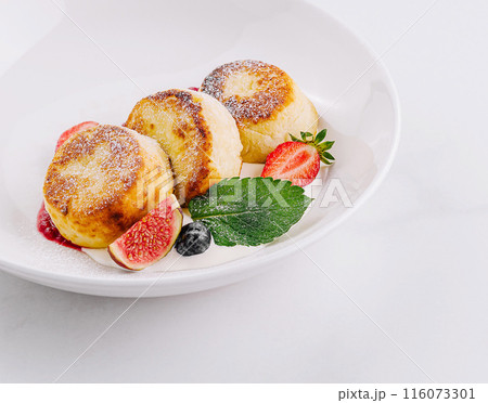 Fresh homemade cottage cheese pancakes with strawberries on white plate 116073301